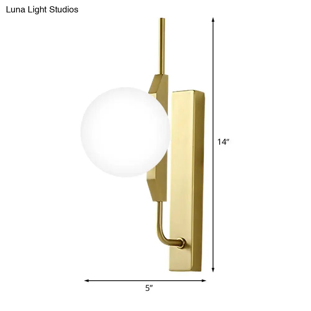 Gold milky glass wall sconce with curved brass arm and round globe by Decorbites on Tampa Home & Garden Store