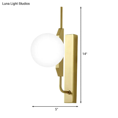 Gold milky glass wall sconce with curved brass arm and round globe by Decorbites on Tampa Home & Garden Store