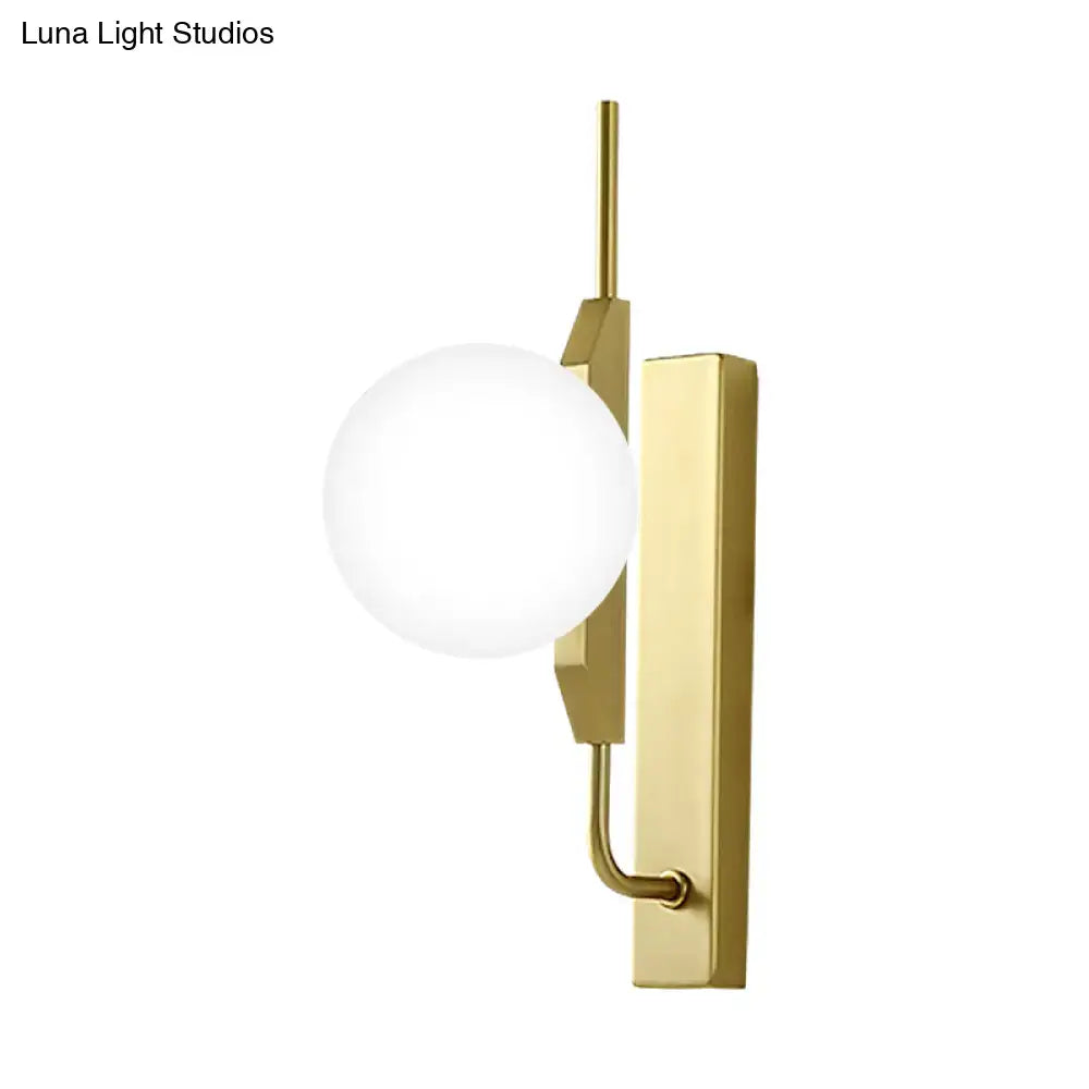 Gold milky glass wall sconce with round white globe and brass backplate on Tampa Home & Garden Store