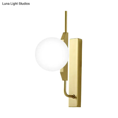 Gold milky glass wall sconce with round white globe and brass backplate on Tampa Home & Garden Store