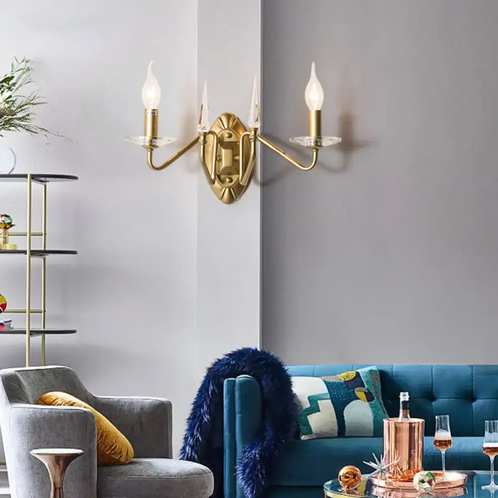 Gold brass two-arm candle sconce with candle-style bulbs and clear glass cups on ornate backplate on Tampa Home & Garden Store