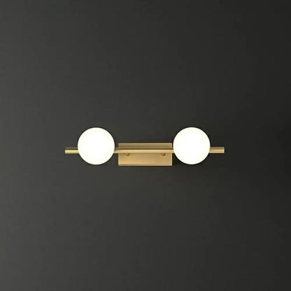 Gold milky glass two-light bathroom sconce on brass bar against dark wall on Tampa Home & Garden Store