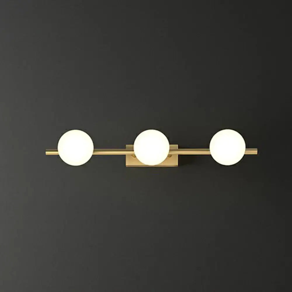 Gold milky glass bathroom sconce with three spherical globes on brass bar on Tampa Home & Garden Store