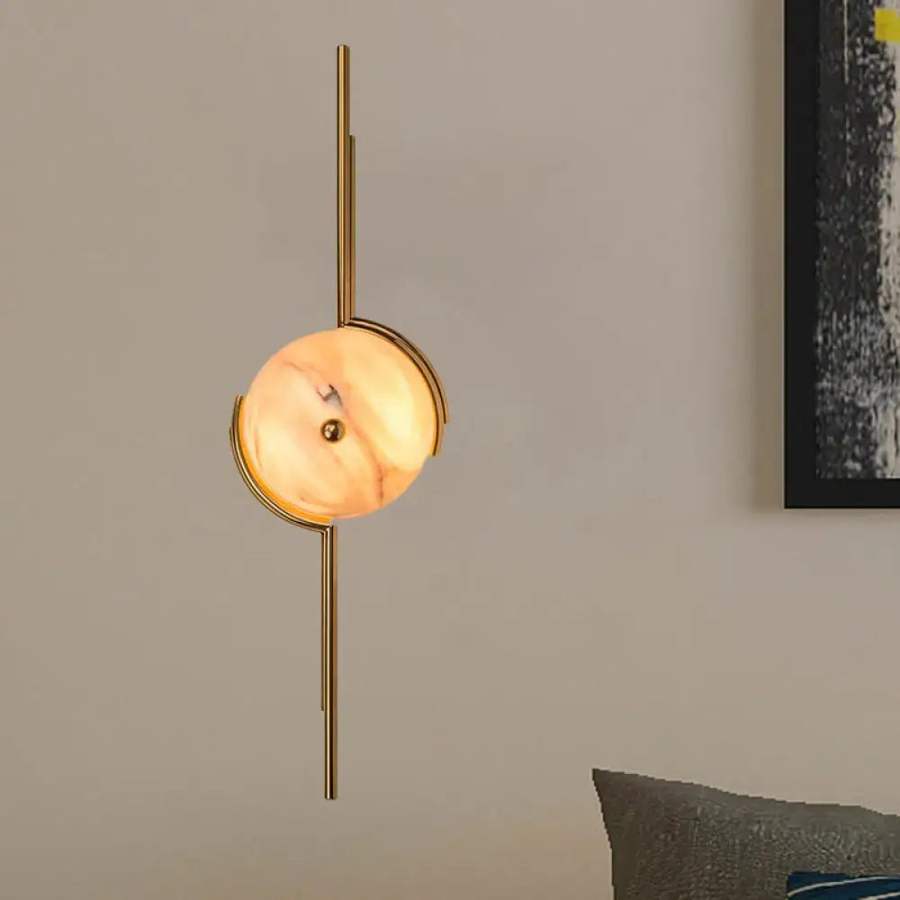 Gold marble LED wall light with round marble disc on a vertical gold metal mount on Tampa Home & Garden Store