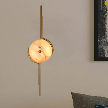 Gold marble LED wall light with round marble disc on a vertical gold metal mount on Tampa Home & Garden Store