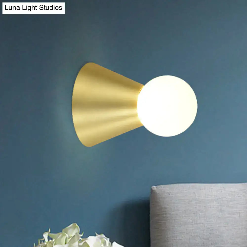 Gold conical frosted-globe wall sconce in brass finish by Decorbites on blue wall on Tampa Home & Garden Store