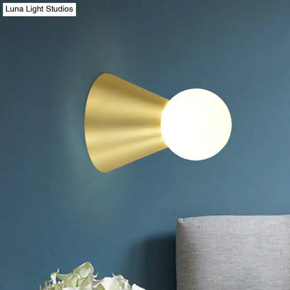 Gold conical frosted-globe wall sconce in brass finish by Decorbites on blue wall on Tampa Home & Garden Store