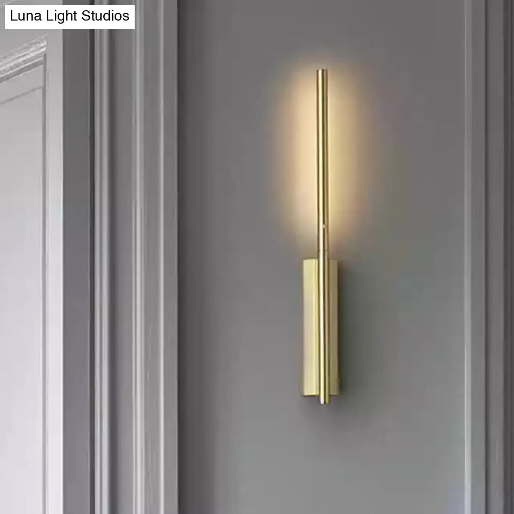 Gold linear reading nook sconce with vertical tube and rectangular backplate on gray wall on Tampa Home & Garden Store