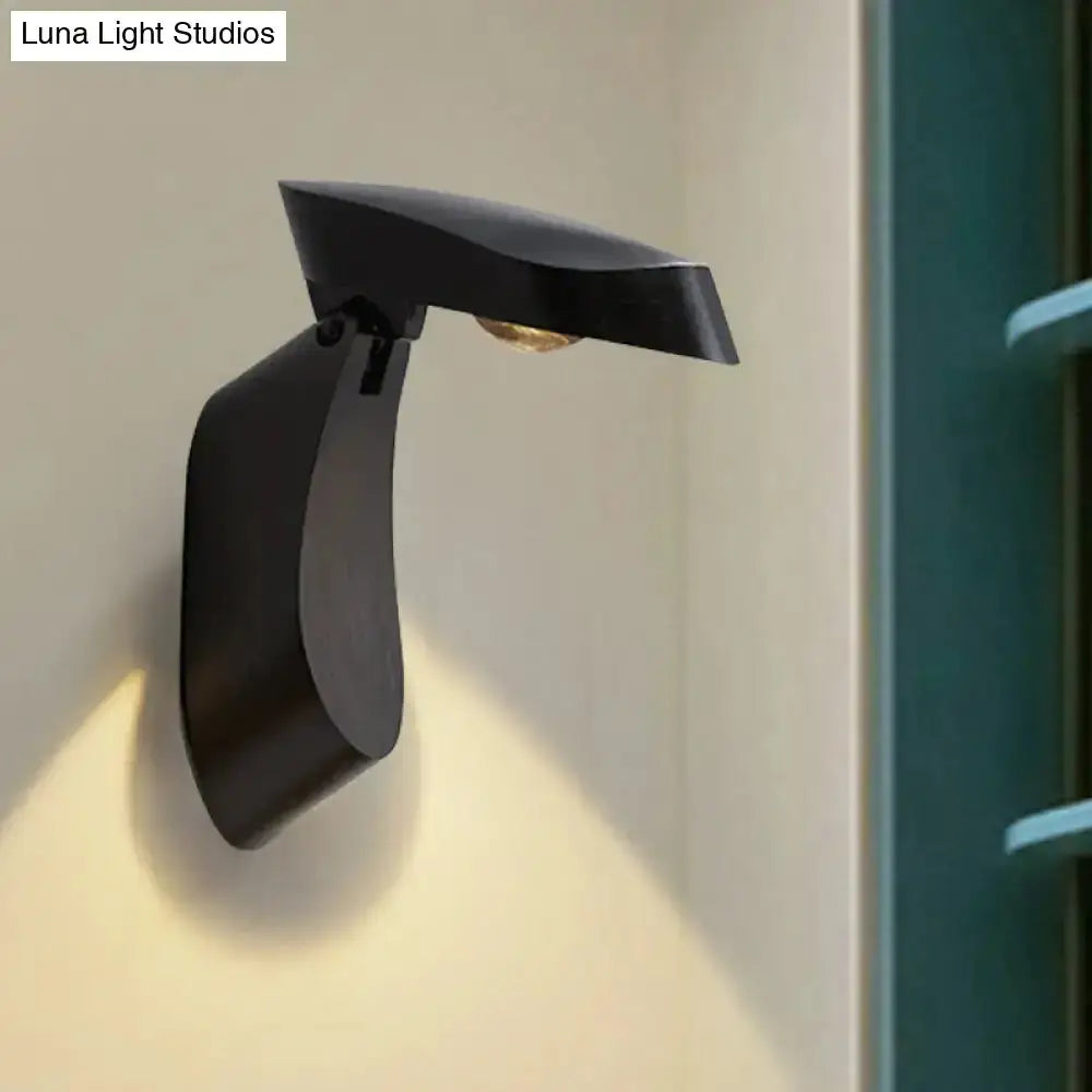 Black metal wall light bedside fixture with curved arm and slim downward shade on Tampa Home & Garden Store