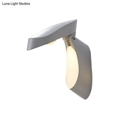 Modern gold metal wall light bedside fixture with curved arm and warm glow on Tampa Home & Garden Store