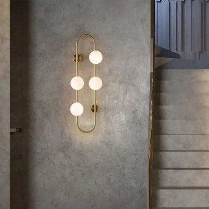 Gold milky glass wall sconce with four globe bulbs on an oval brass frame Decorbites on Tampa Home & Garden Store