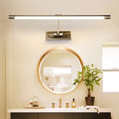 Modern gold minimalist metal LED sconce above a round gold-framed bathroom mirror on Tampa Home & Garden Store
