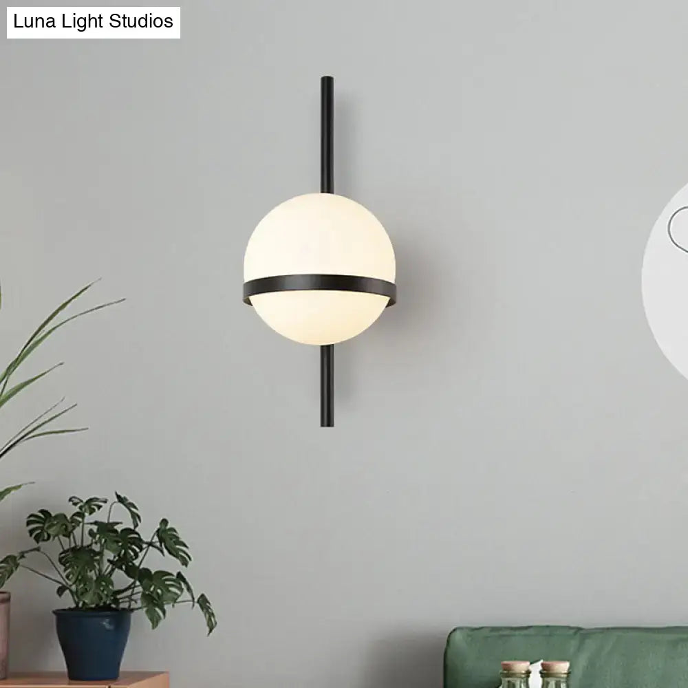 Gold opal glass wall sconce on a black vertical mount with a dark ring around the globe on Tampa Home & Garden Store