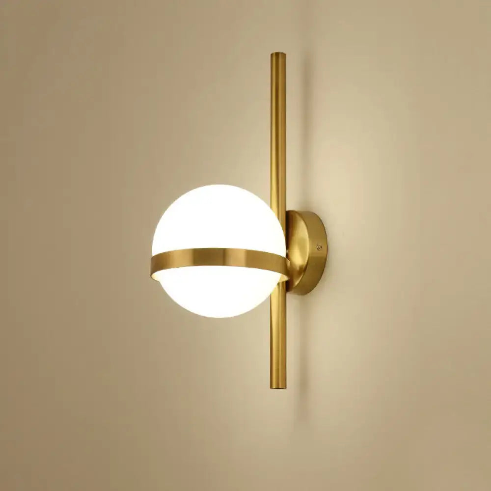 Gold opal glass wall sconce with brass vertical rod and circular band around the globe light on Tampa Home & Garden Store