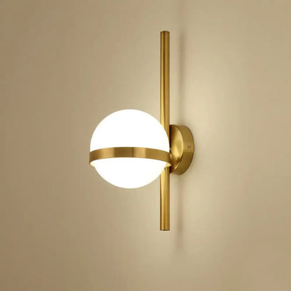Gold opal glass wall sconce with brass vertical rod and circular band around the globe light on Tampa Home & Garden Store