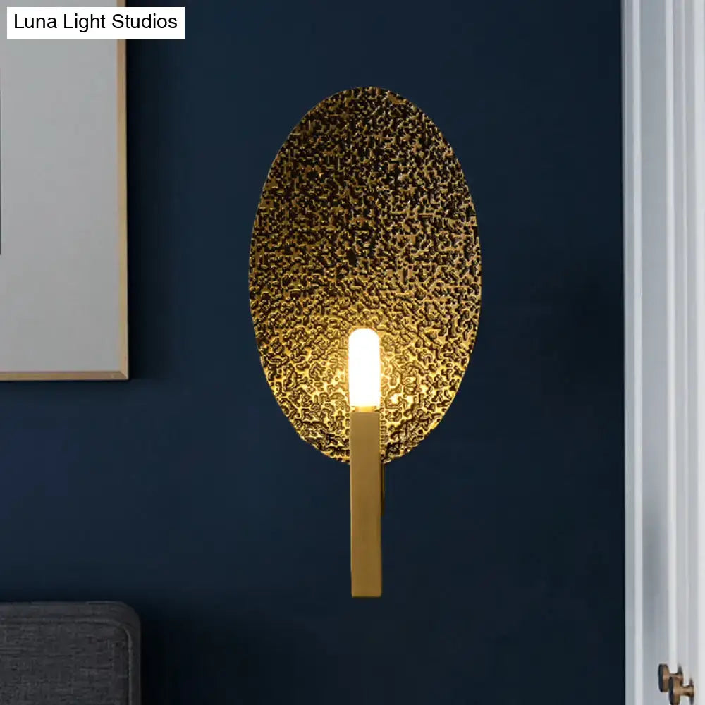 Gold metal speckled glass sconce with oval backplate and warm glow by Decorbites on Tampa Home & Garden Store