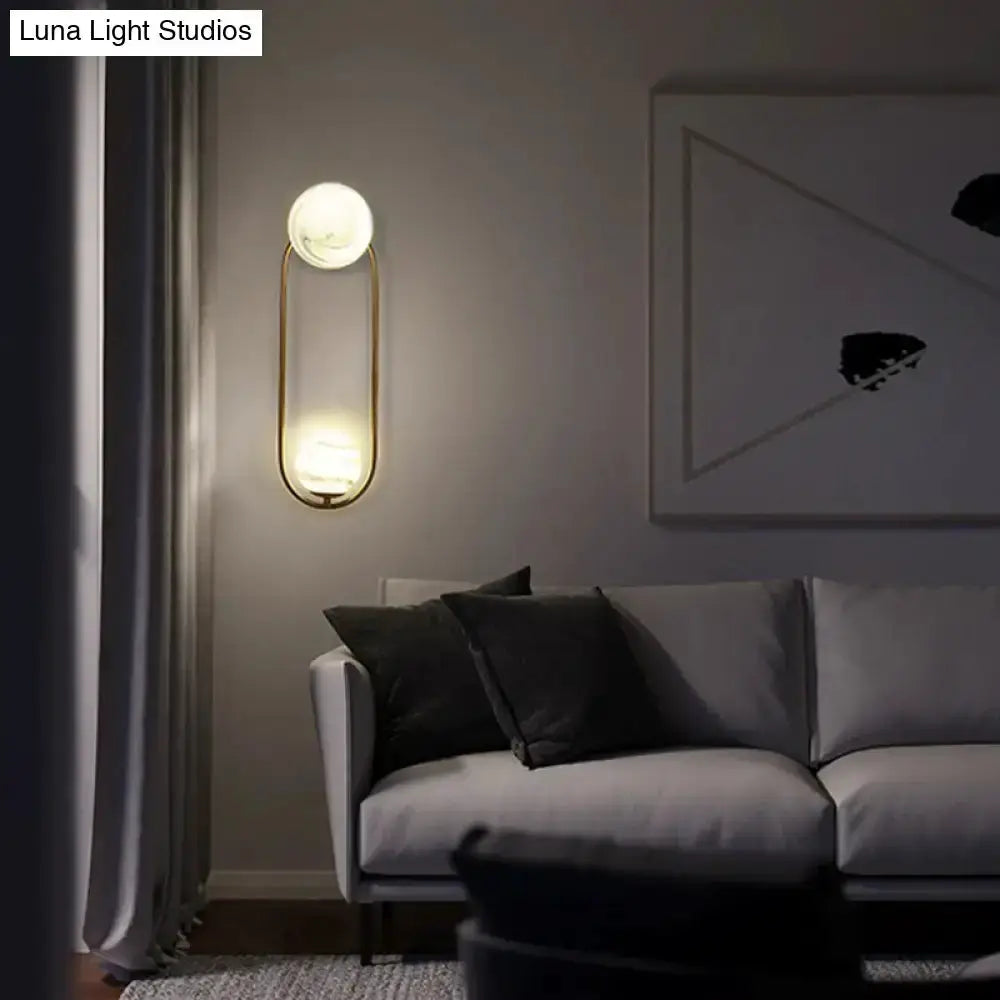 Modern gold oval wall sconce with white marble shade accents for living room decor on Tampa Home & Garden Store