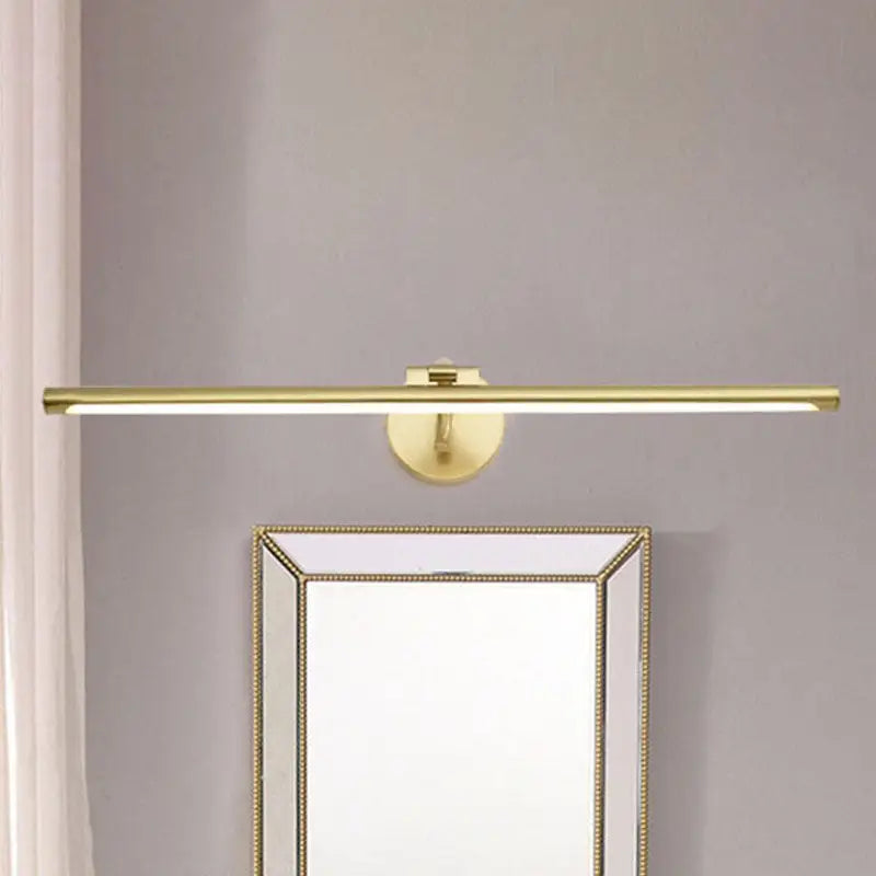 Decorbites gold pipe vanity light, gold metal bar wall mount above a framed mirror on Tampa Home & Garden Store