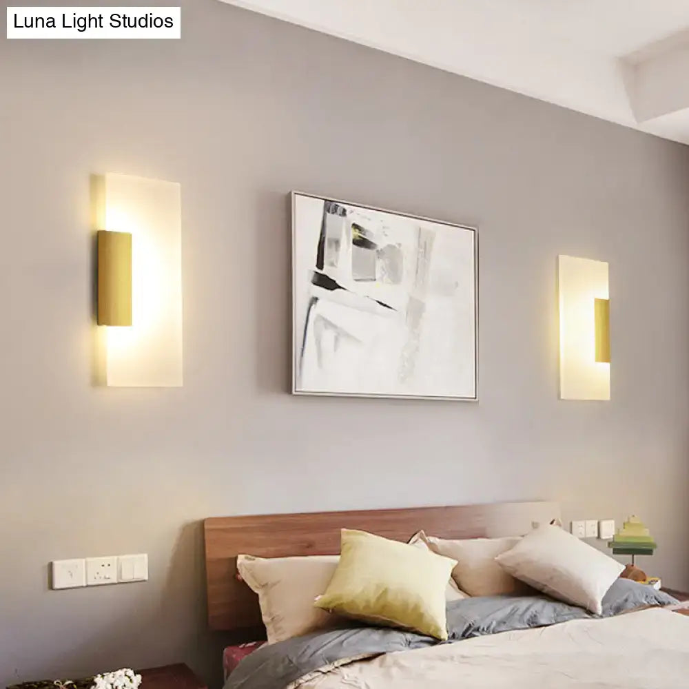 Gold acrylic wall sconce pair with warm LED glow on gray wall beside bed on Tampa Home & Garden Store