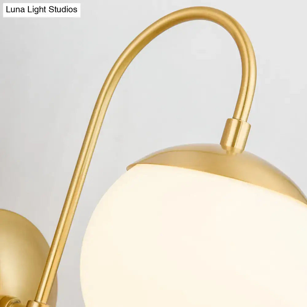 Gold opal glass wall lamp with curved brass arm and frosted globe by Decorbites on Tampa Home & Garden Store