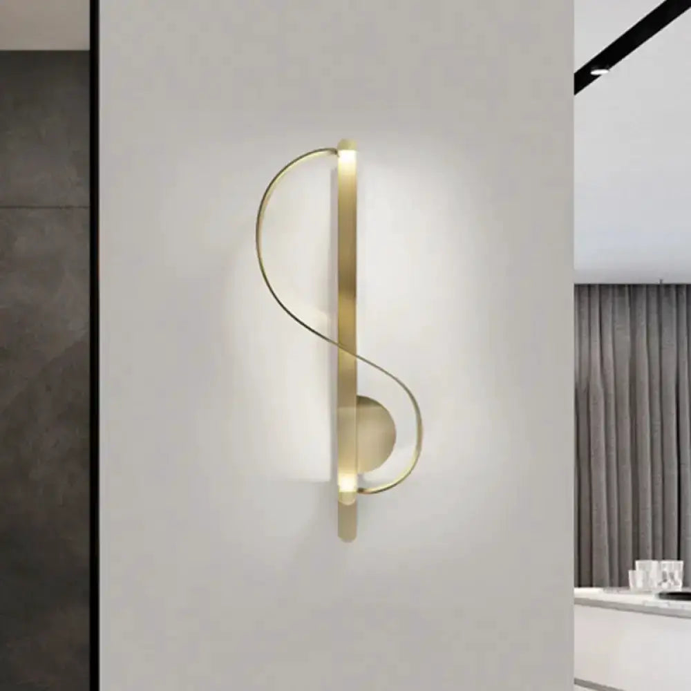 Gold metal s-shaped wall light fixture mounted on neutral wall modern living room corner on Tampa Home & Garden Store