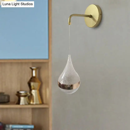 Gold teardrop wall sconce with brass arm and round backplate on Tampa Home & Garden Store