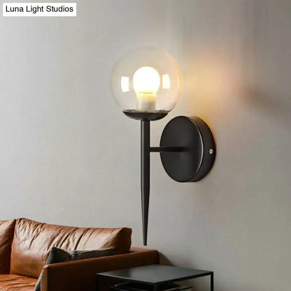 Gold Glass Torch Sconce with black metal wall mount and clear glass globe on Tampa Home & Garden Store