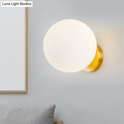 Gold opal glass wall lamp with round frosted globe and brass base by Decorbites on Tampa Home & Garden Store