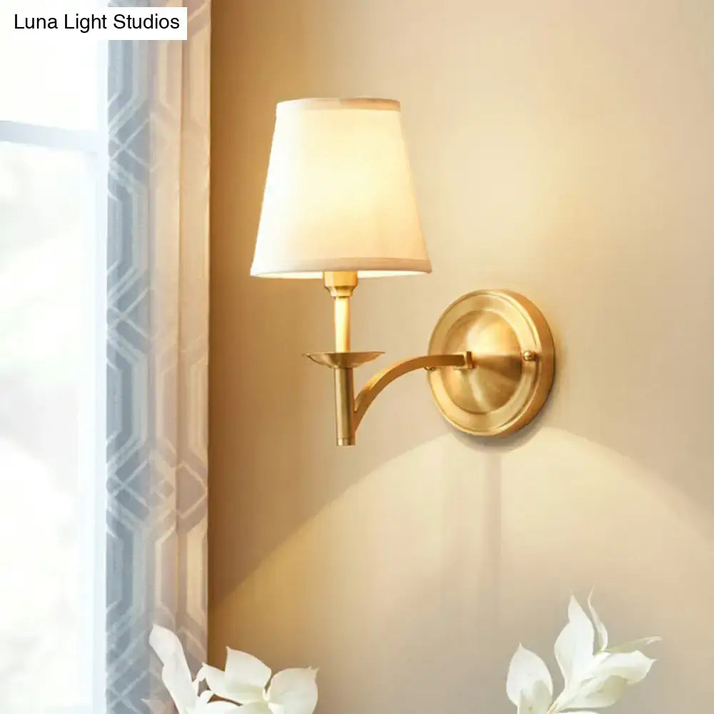 Gold fabric wall sconce with curved brass arm and white shade by Decorbites on Tampa Home & Garden Store