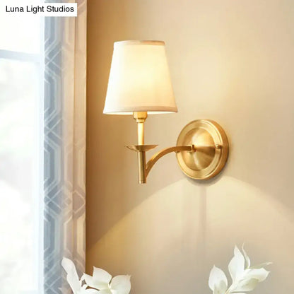 Gold fabric wall sconce with curved brass arm and white shade by Decorbites on Tampa Home & Garden Store