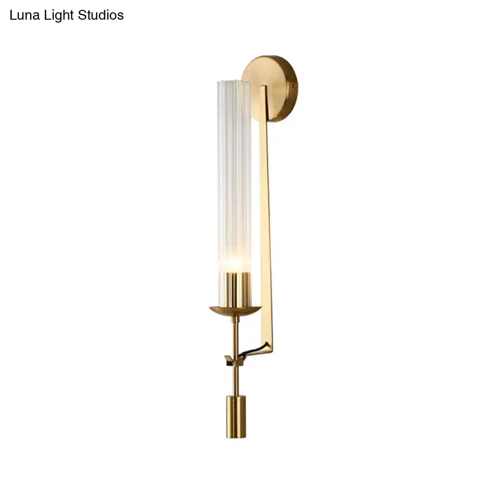 Gold glass bathroom sconce by Decorbites with a tall ribbed glass shade and brass backplate on Tampa Home & Garden Store