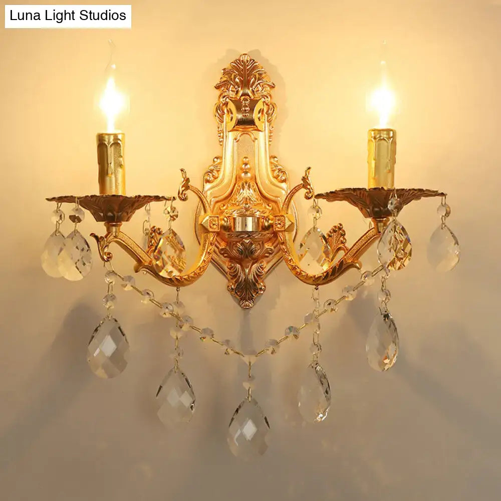 Gold crystal candelabra sconce with two candle-style arms and hanging prisms by Decorbites on Tampa Home & Garden Store