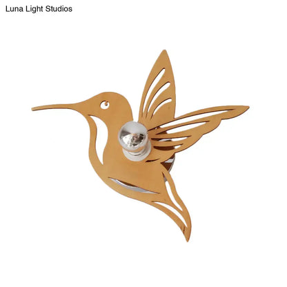 Beige hummingbird wall sconce with metal silhouette and cutout wings, chrome bulb holder on Tampa Home & Garden Store