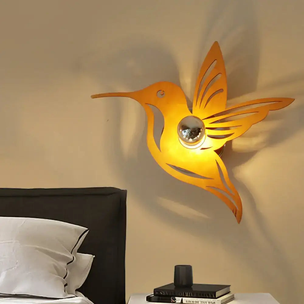 Beige Hummingbird Wall Sconce by Decorbites with warm yellow metal silhouette on wall on Tampa Home & Garden Store