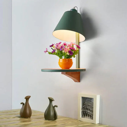 Gray tapered shade sconce by Decorbites on wall above a shelf with orange vase and flowers on Tampa Home & Garden Store