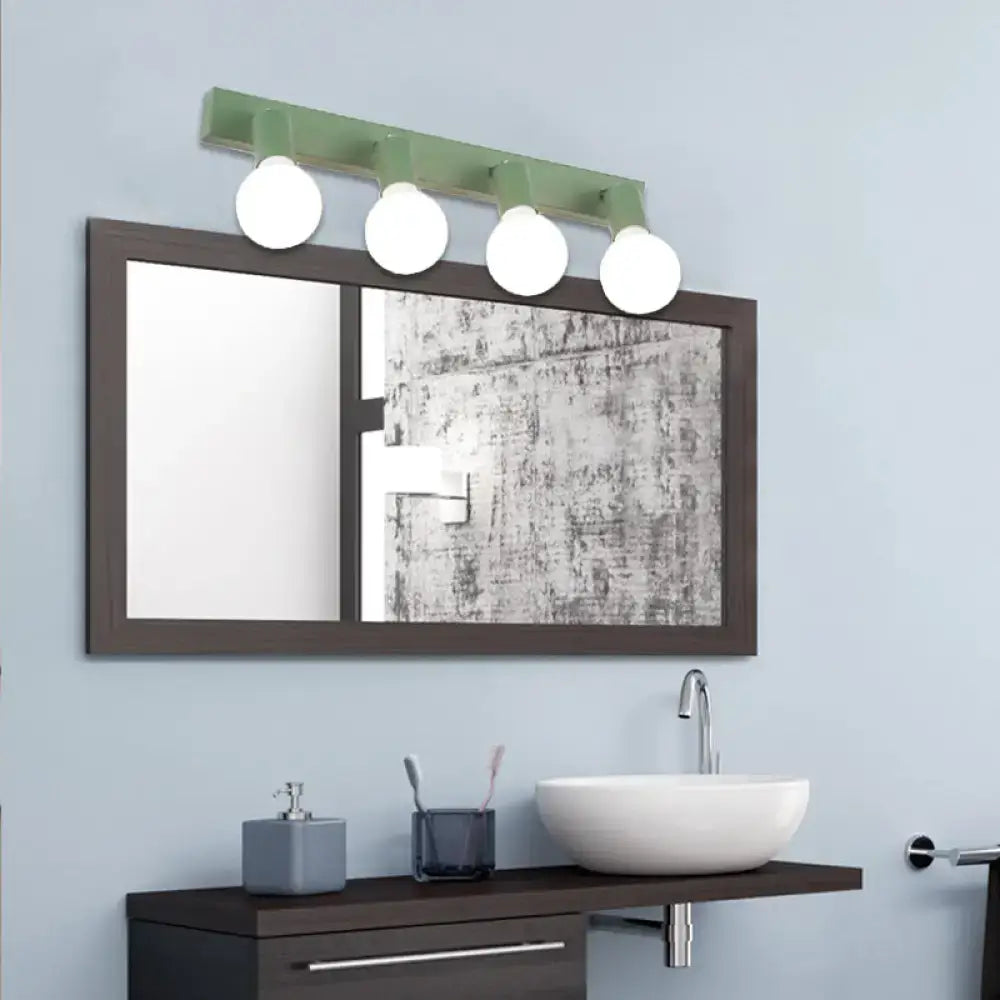Green linear vanity light four-bulb design by Decorbites over dark framed bathroom mirror on Tampa Home & Garden Store
