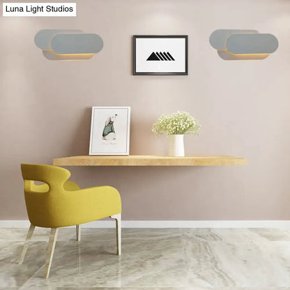 Grey oval metal sconce pair by Decorbites with warm glow above a desk in a beige room on Tampa Home & Garden Store