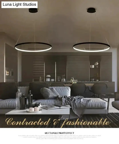 Pendant lights: interlocking ring LED fixtures, black rings with glow above dining area on Tampa Home & Garden Store