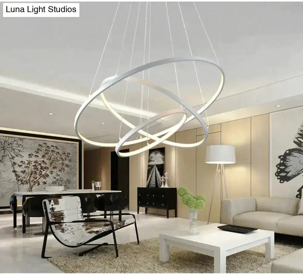 Modern interlocking ring LED pendant lights in silver metal over dining area on Tampa Home & Garden Store