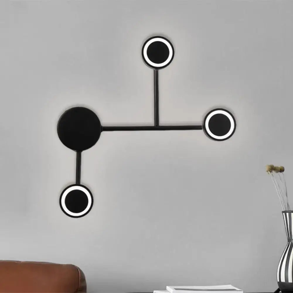 Black industrial warm LED wall sconce with interconnected circular ring lights and hub on Tampa Home & Garden Store