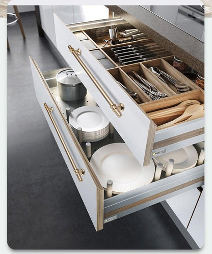 Cabinet pulls and drawer handles in brass tone on white kitchen drawers with utensils on Tampa Home & Garden Store