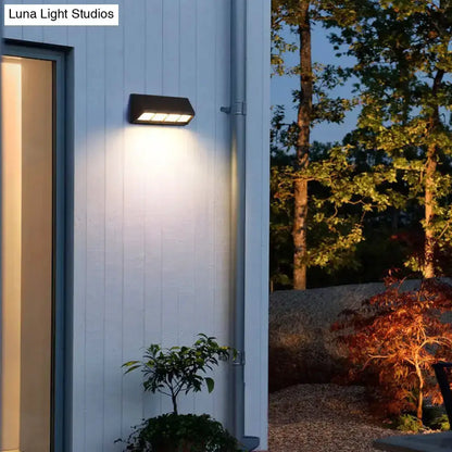 Modern matte black LED outdoor wall sconce, rectangular 110V–120V fixture on white wall on Tampa Home & Garden Store