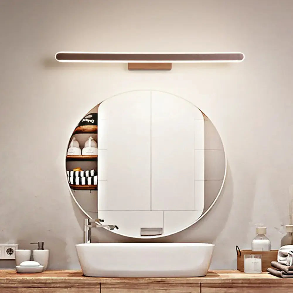 Coffee Linear LED Sconce by Decorbites in copper finish mounted above a round bathroom mirror on Tampa Home & Garden Store