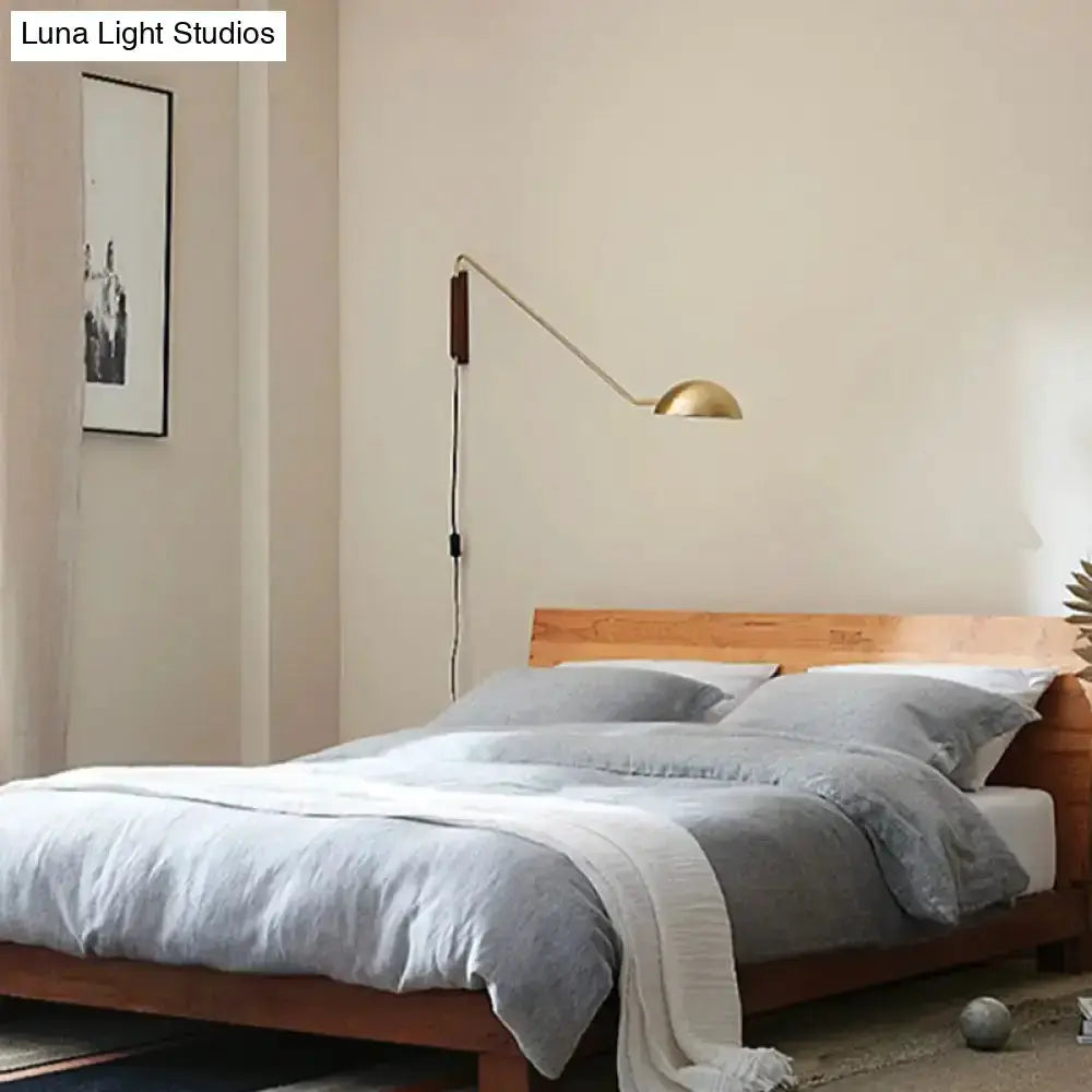 Modern matte black swing-arm bedside wall lamp with wood mount and gold dome shade on Tampa Home & Garden Store