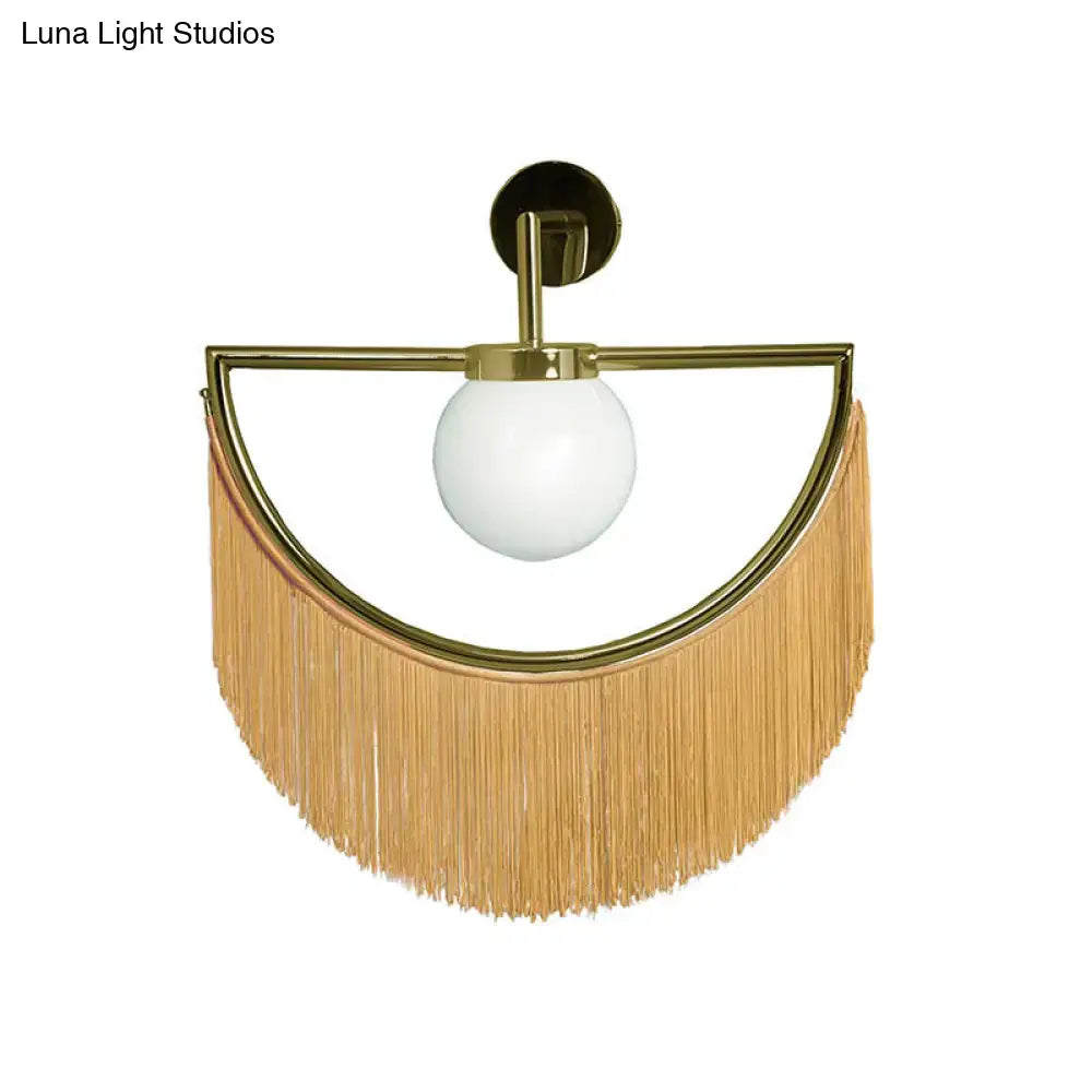 Decorbites white glass wall sconce with gold semi-circular frame and tan fringe tassels on Tampa Home & Garden Store