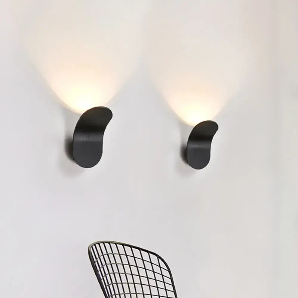 Pair of black industrial wall sconces with curved brackets, matte finish, upward glow on white wall on Tampa Home & Garden Store