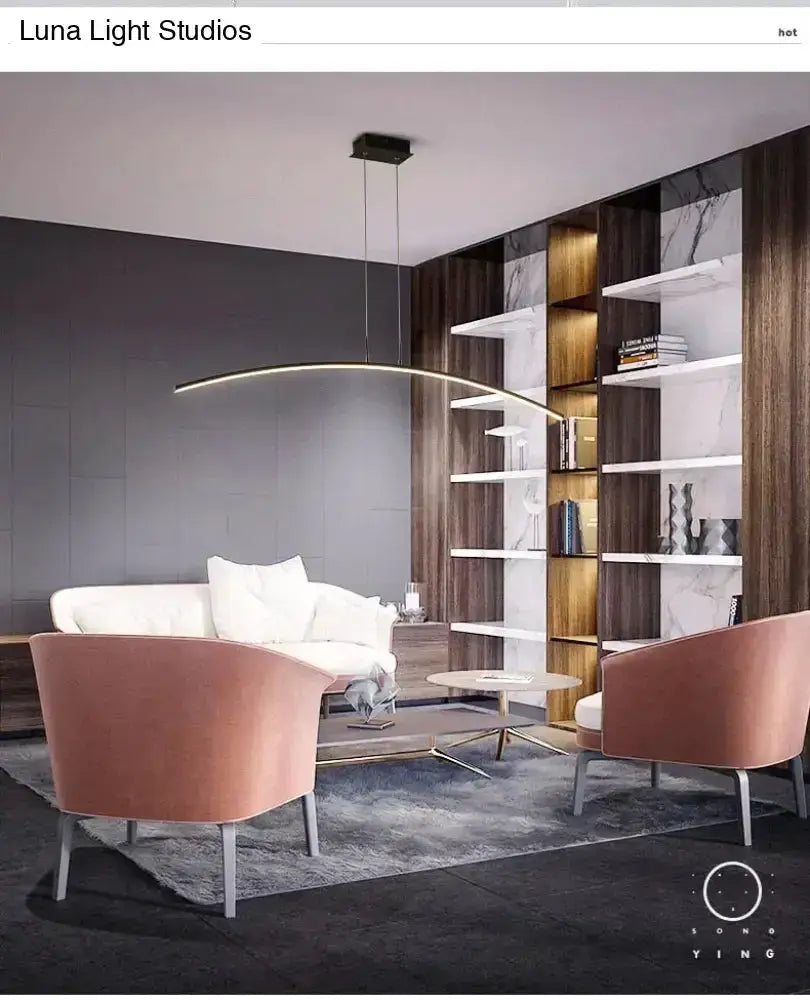 Decorbites arc-shaped metallic LED pendant light over a modern living room with pink chairs on Tampa Home & Garden Store