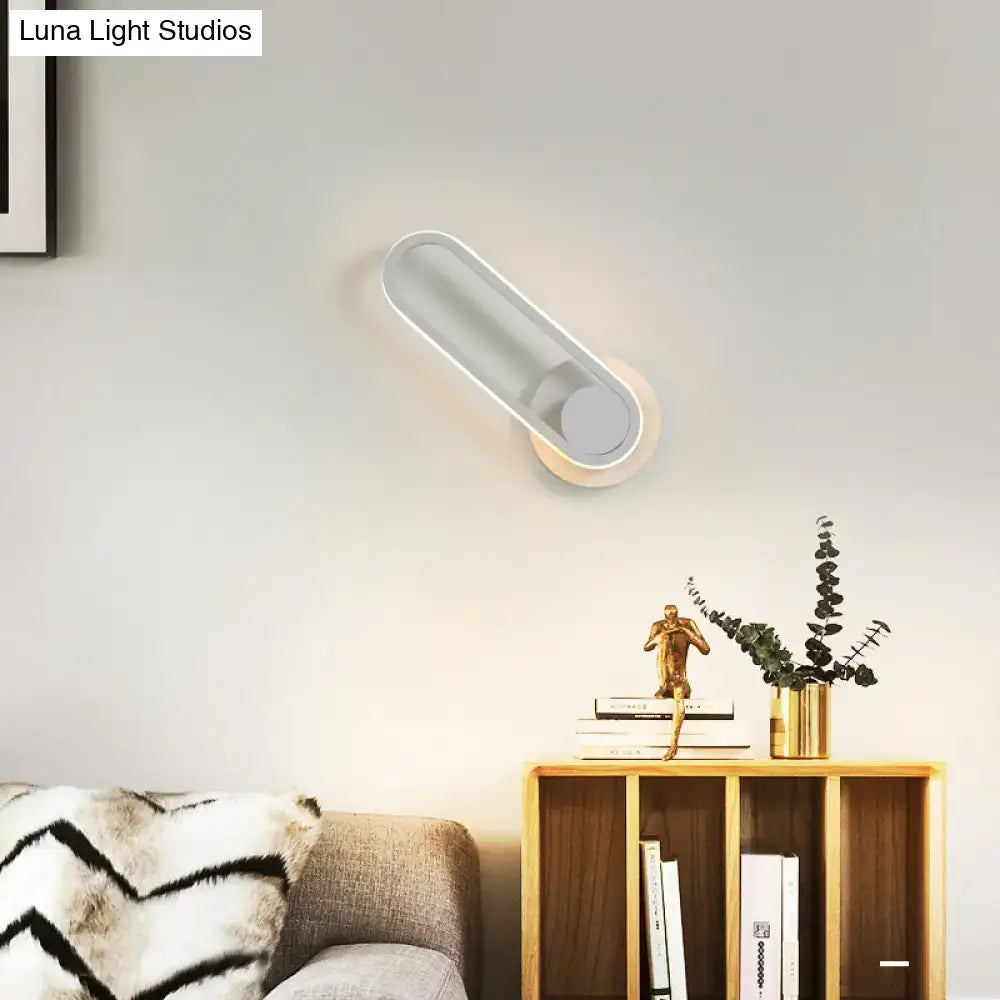 Matte Oval Wall Sconce white finish with warm glow mounted on wall above a bookshelf Decorbites on Tampa Home & Garden Store