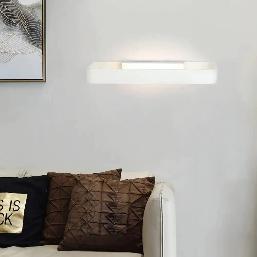 White rectangular modern minimalist wall lamp with warm glow above sofa on Tampa Home & Garden Store