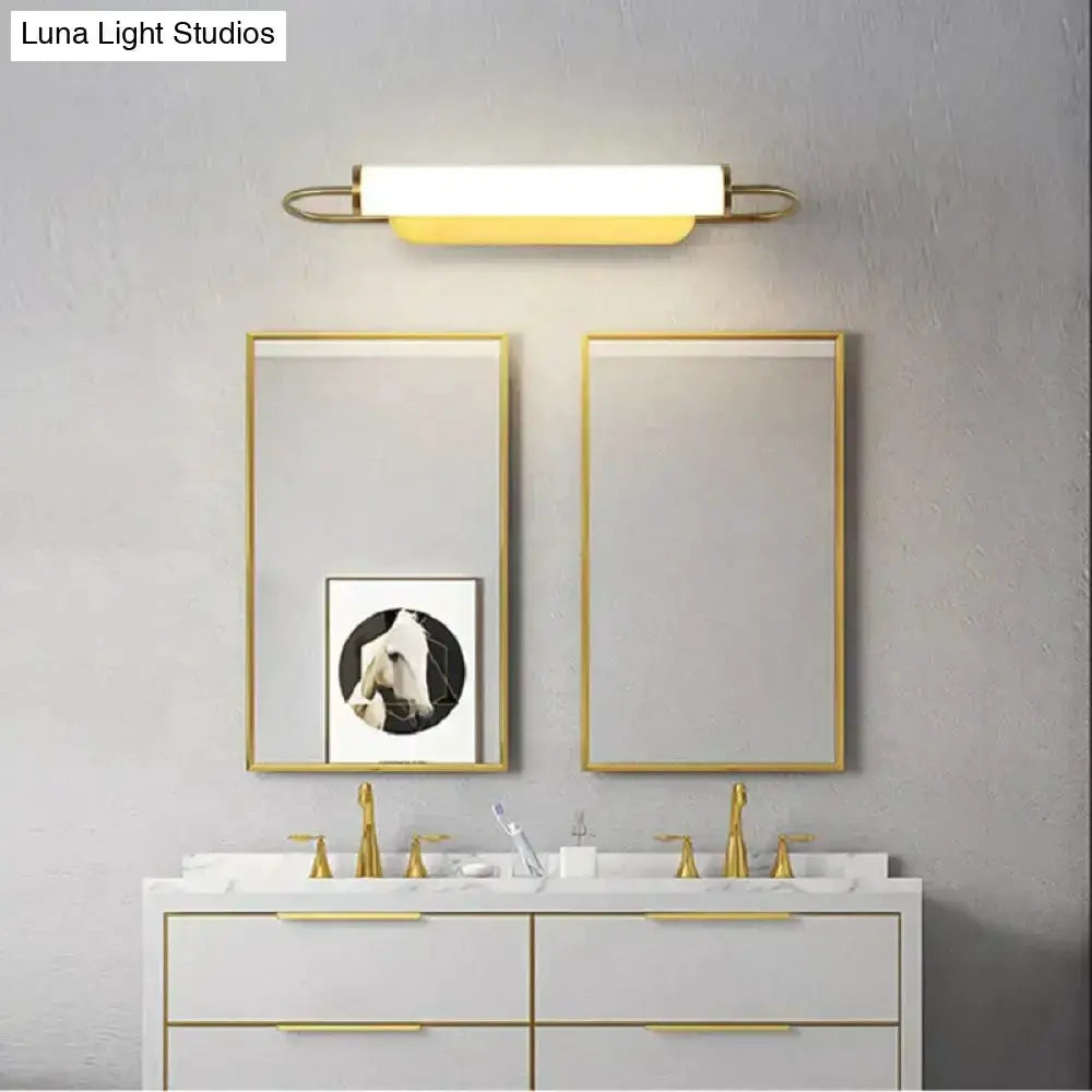 Gold LED cylindrical wall lamp sconce by Decorbites above a white vanity with gold trim on Tampa Home & Garden Store